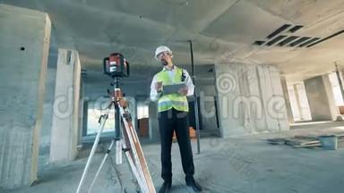 建筑工人在一个建筑工地调节土地测量设备